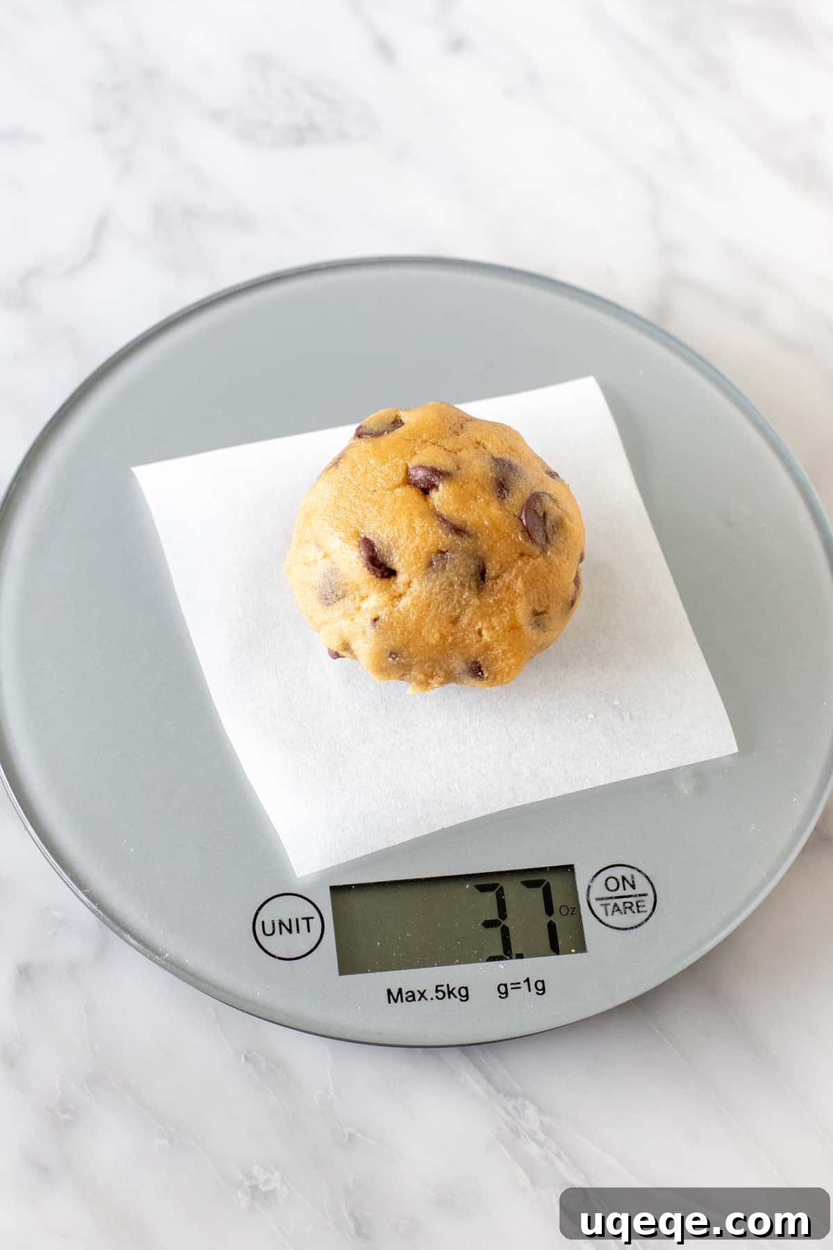 Signature Bakery Chocolate Chip Delights 4 A perfectly portioned cookie dough ball resting on a digital baking scale, showing its exact weight.