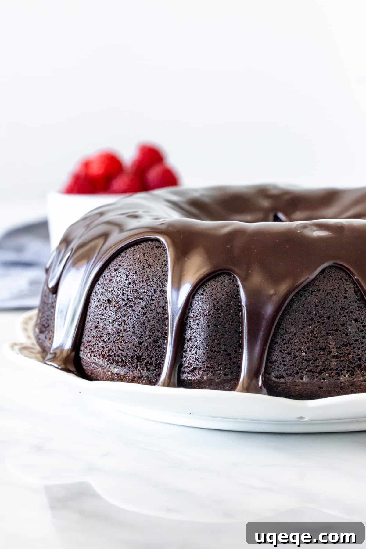 Decadent Chocolate Pound 3 Chocolate pound cake with chocolate drizzled on top on a white plate