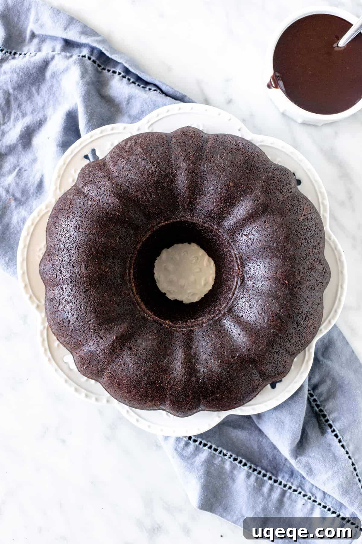Decadent Chocolate Pound 4 Chocolate cake made in a bundt pan on a plate with ganache
