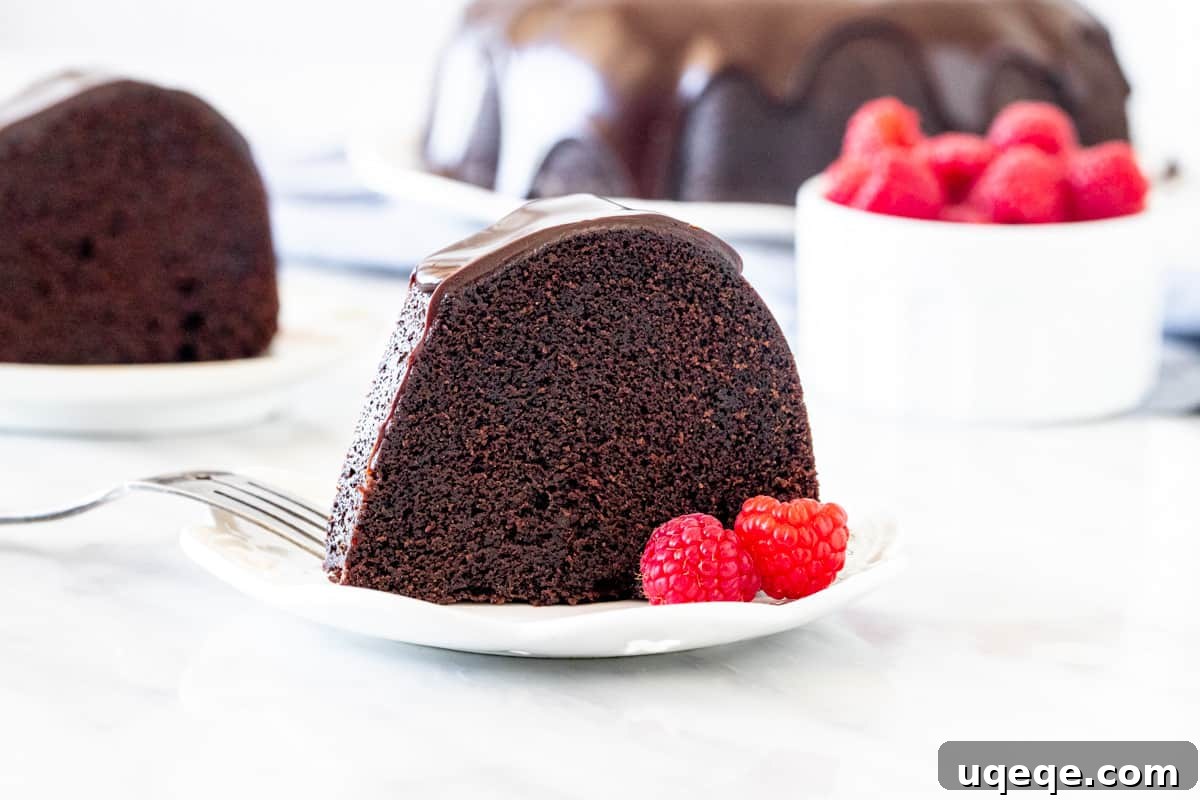 Decadent Chocolate Pound 5 Slice of chocolate bundt cake with a few raspberries and ganache