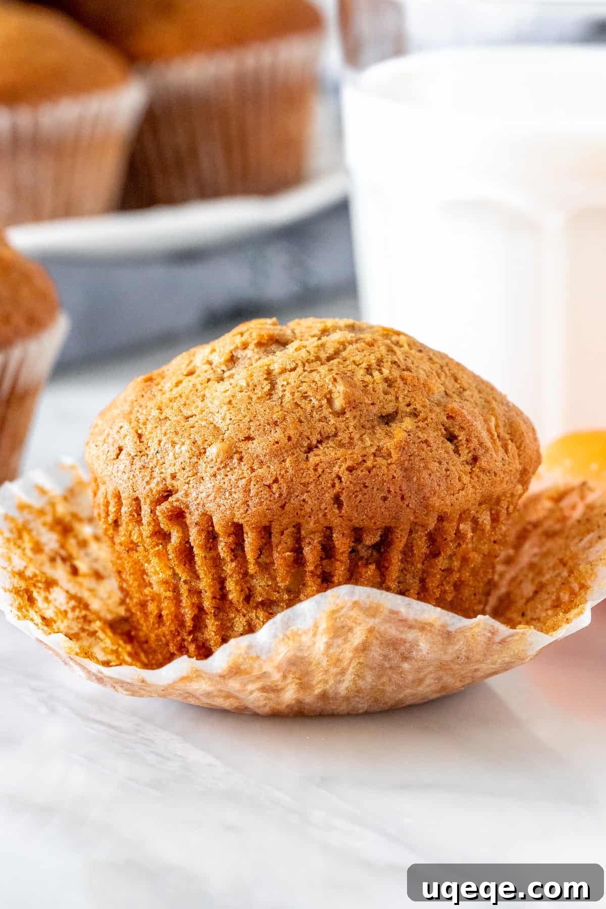 Spiced Carrot Cake Muffins 2 Carrot cake muffin with a glass of milk, emphasizing its moist texture and perfect domed top