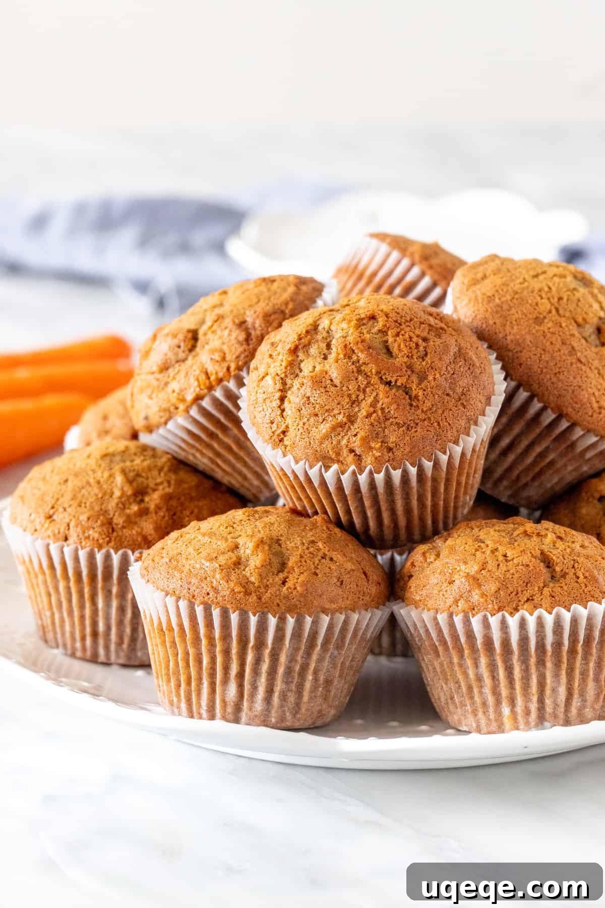 Spiced Carrot Cake Muffins 3 A plate brimming with freshly baked, golden-brown carrot muffins, ready to be served.