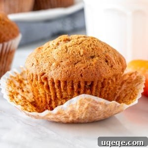 Close-up of a single moist carrot cake muffin with its paper liner
