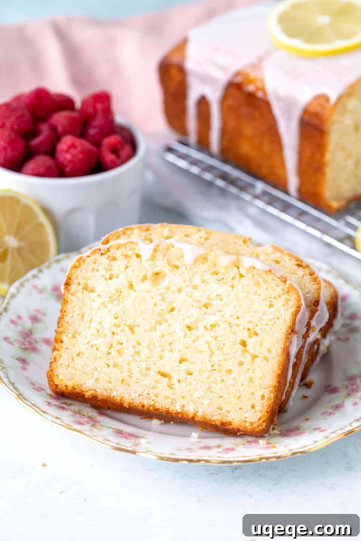 Small plate with two slices of glazed lemon loaf cake, ready to be enjoyed with coffee