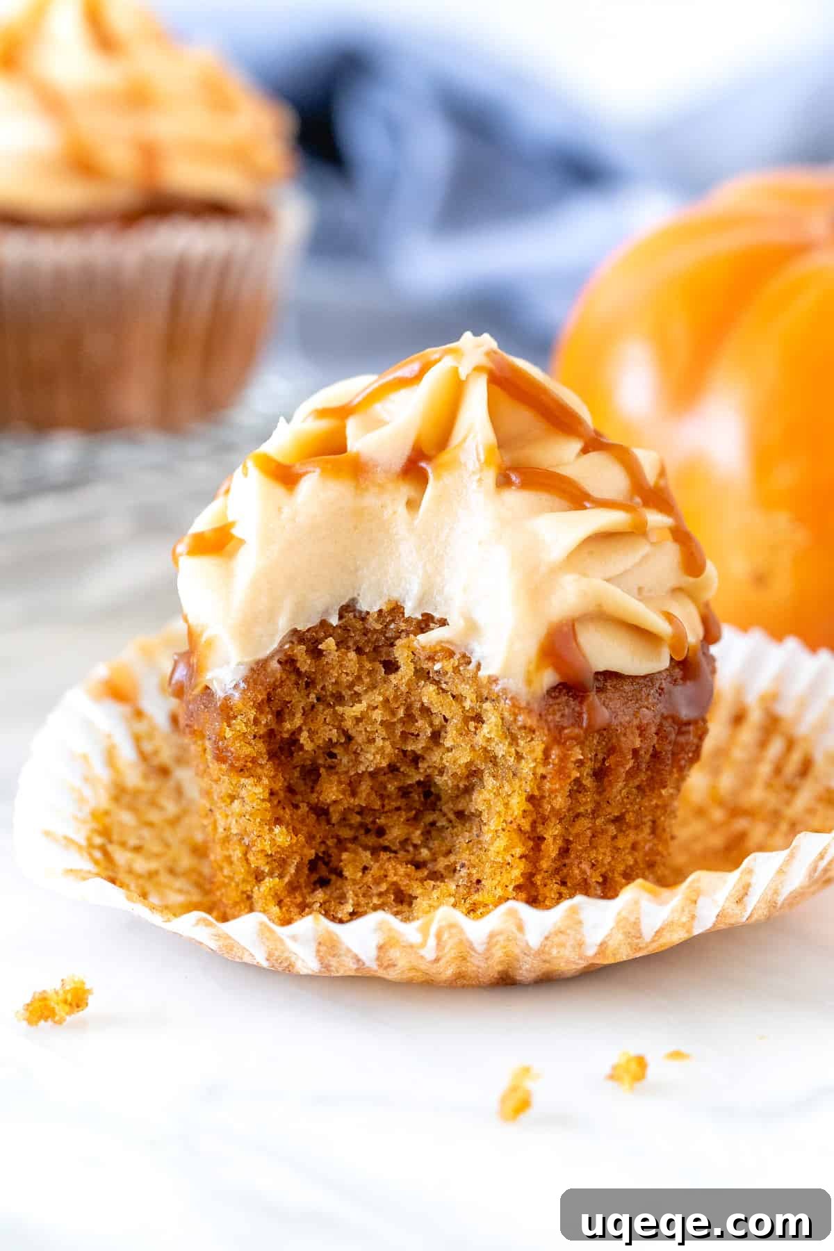Rich Pumpkin Spice Cupcakes with Caramel Cream Cheese Swirl 4 Pumpkin caramel cupcake with a bite taken out of it.