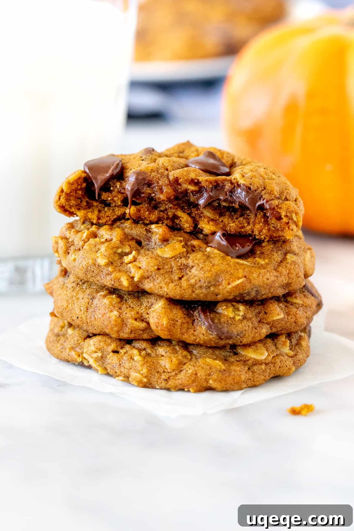 Stack of pumpkin chocolate chip oatmeal cookies with a glass of milk.