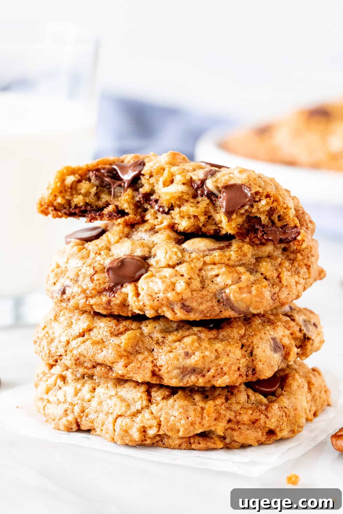 Chuckwagon Chews 5 A stack of oatmeal coconut chocolate chip cookies, with the top cookie broken in half to reveal its chewy interior
