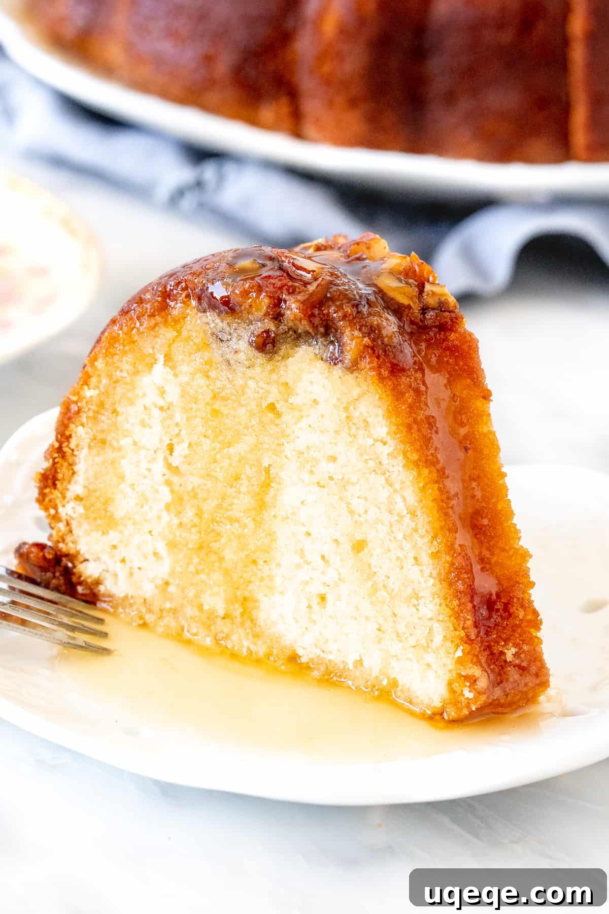 Decadent Homemade Rum Cake 4 A slice of rum cake, moist and golden, with more rum sauce generously poured over the top.