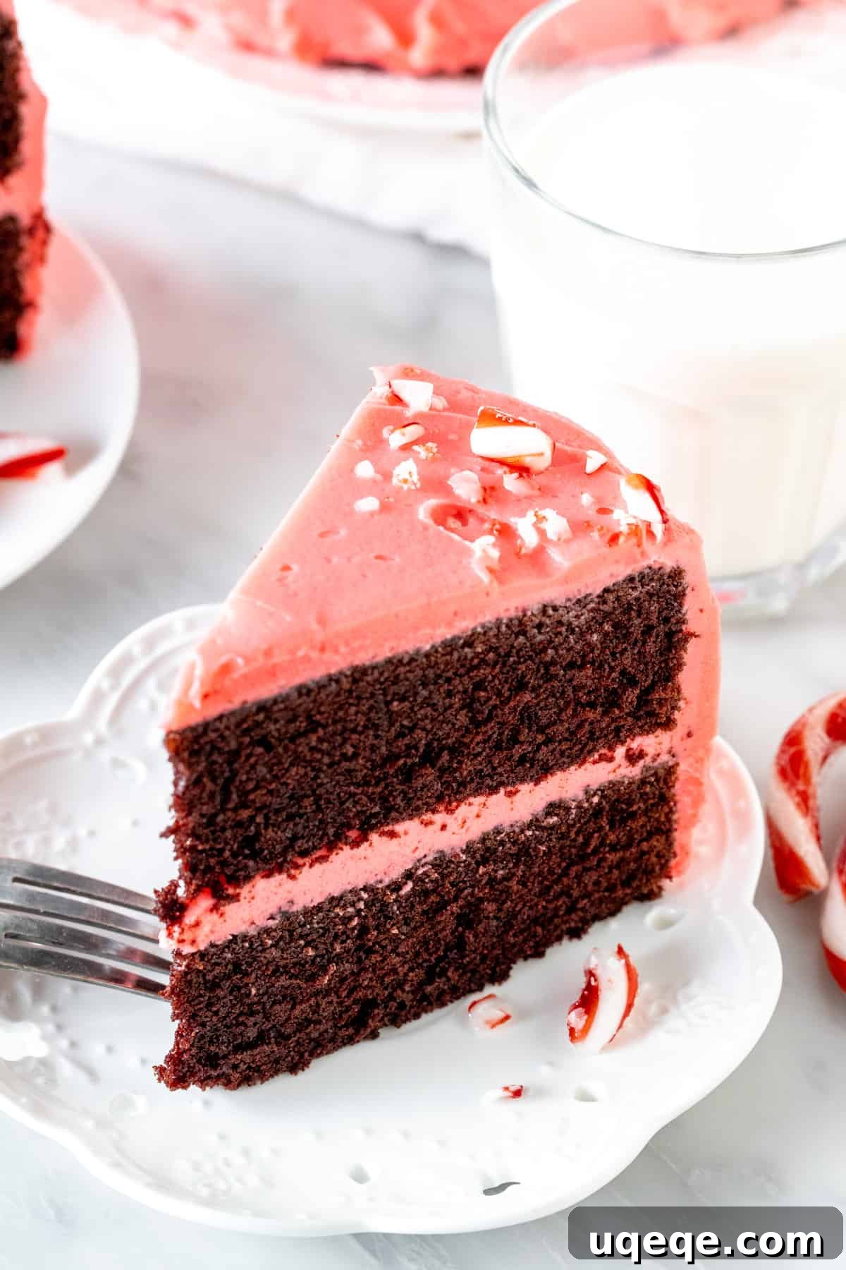 Peppermint Twist Chocolate Cake 2 A beautifully sliced piece of chocolate peppermint cake showing distinct layers, served alongside a refreshing glass of milk, highlighting its decadent appeal for Christmas.