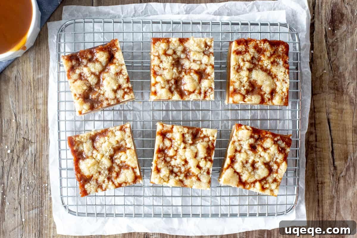 Salted Caramel Shortbread Crumble Bars 3 Six freshly baked caramel butter bars cooling on a wire rack, glistening with caramel and sprinkled with crumb topping.