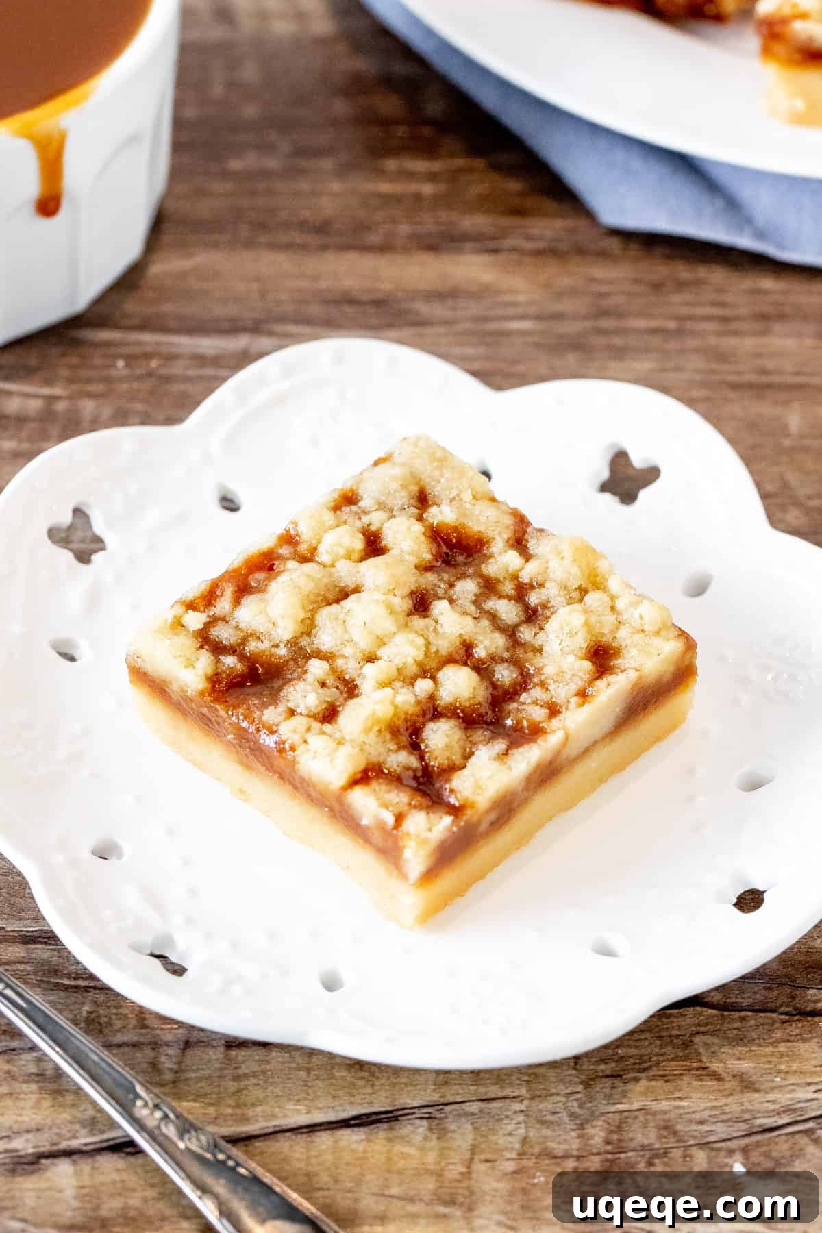 Salted Caramel Shortbread Crumble Bars 4 A single perfect caramel crumb bar, showcasing its three distinct layers and inviting texture, resting on a white plate.