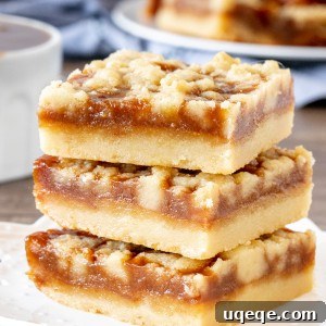 Salted Caramel Shortbread Crumble Bars 5 Three caramel crumb bars, stacked neatly one on top of the other, showing off their layers.