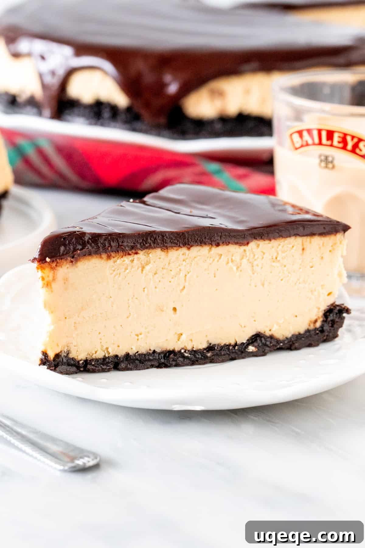 The Ultimate Baileys Irish Cream Cheesecake 2 Slice of Baileys cheesecake with an Oreo crust and glass of Baileys