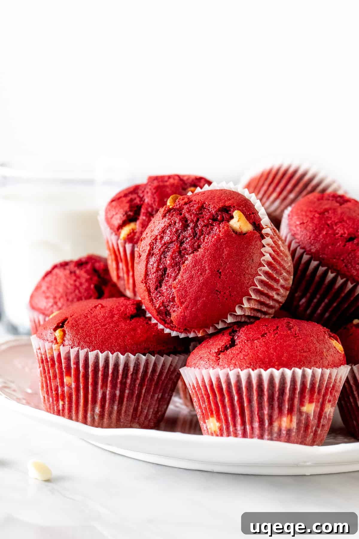 Plate of rich red velvet muffins adorned with chocolate chips, perfect for a special treat or Valentine's Day.