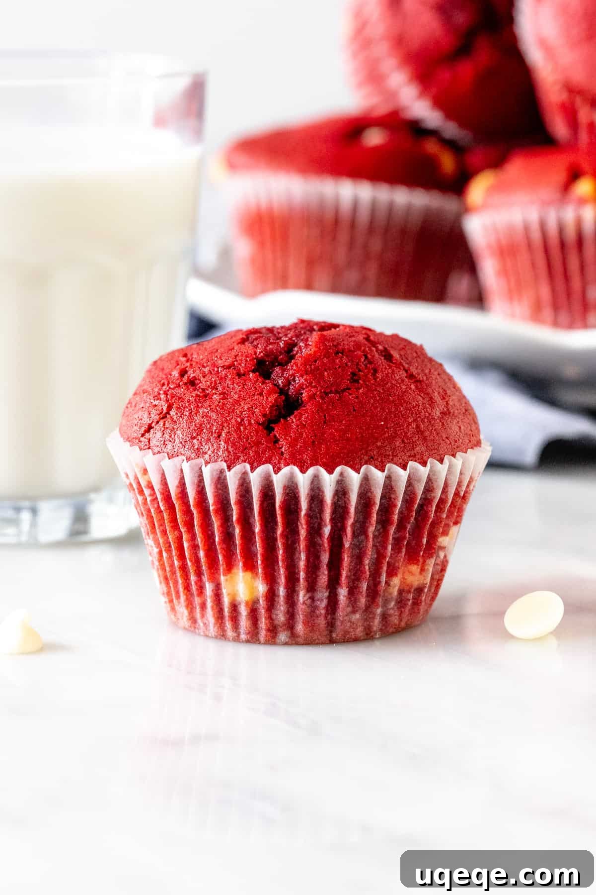 Red velvet chocolate chip muffin with a glass of milk, emphasizing its moist interior and delicious chocolate.