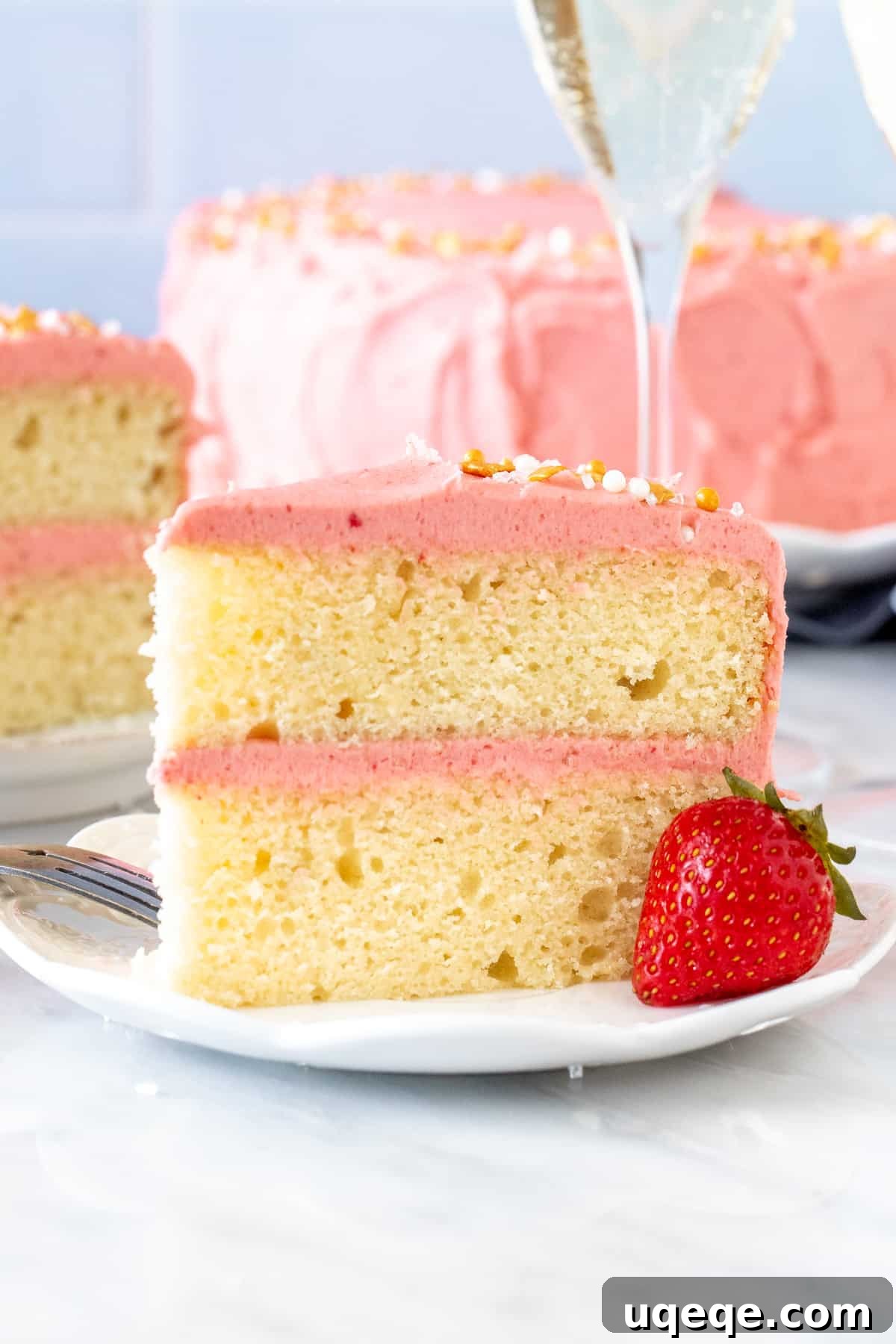 Sparkling Strawberry Bliss Cake 3 Slice of champagne layer cake with strawberry frosting, showcasing its delicate crumb