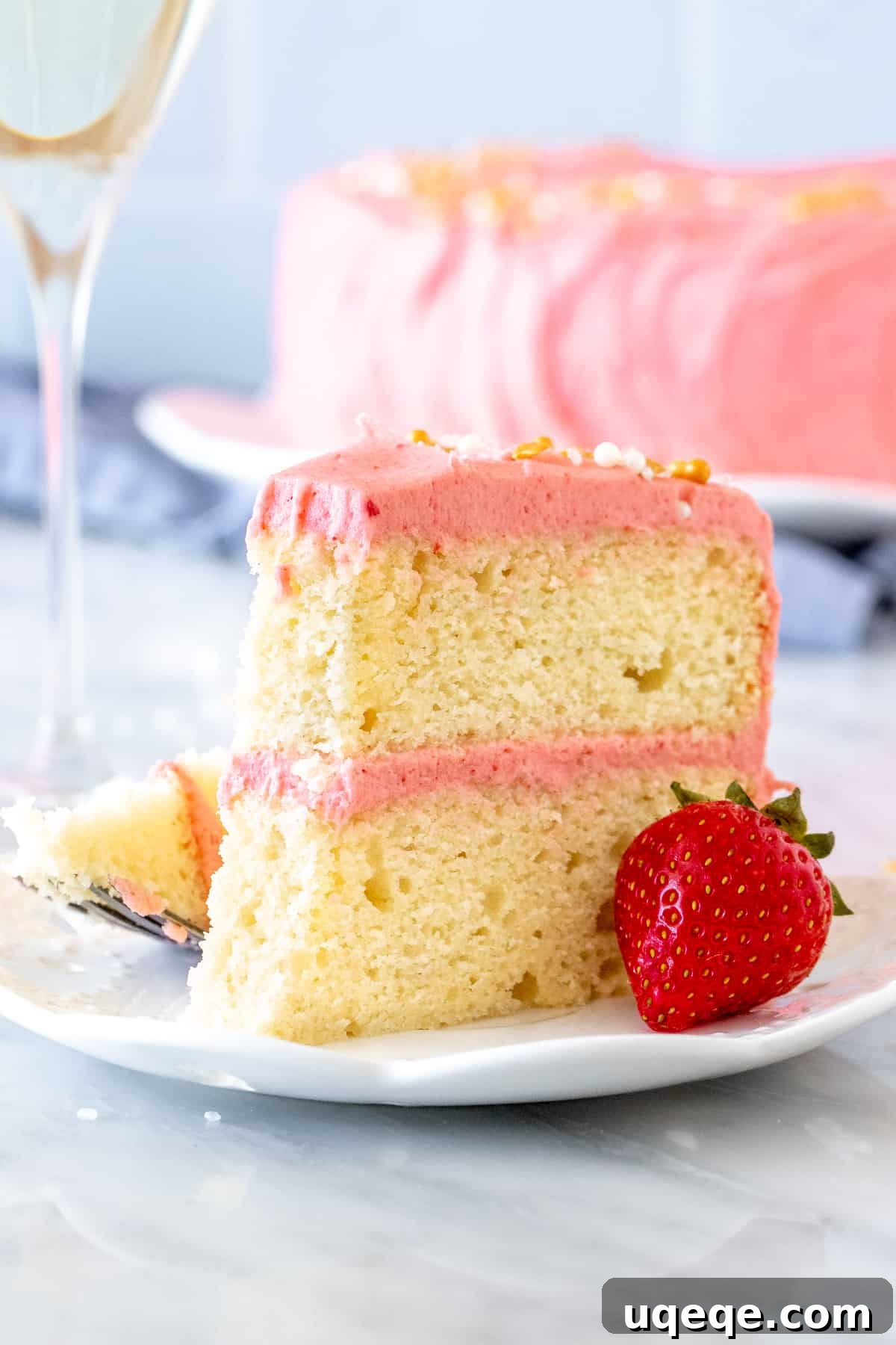 Sparkling Strawberry Bliss Cake 6 Close-up of a slice of Strawberry Champagne Cake with vibrant pink frosting, emphasizing its appealing color and texture.