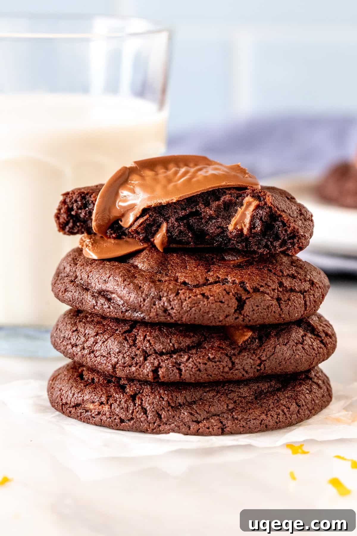Zesty Chocolate Orange Delights 4 Stack of four chocolate orange cookies, showing a broken cookie revealing a gooey, fudgy interior.