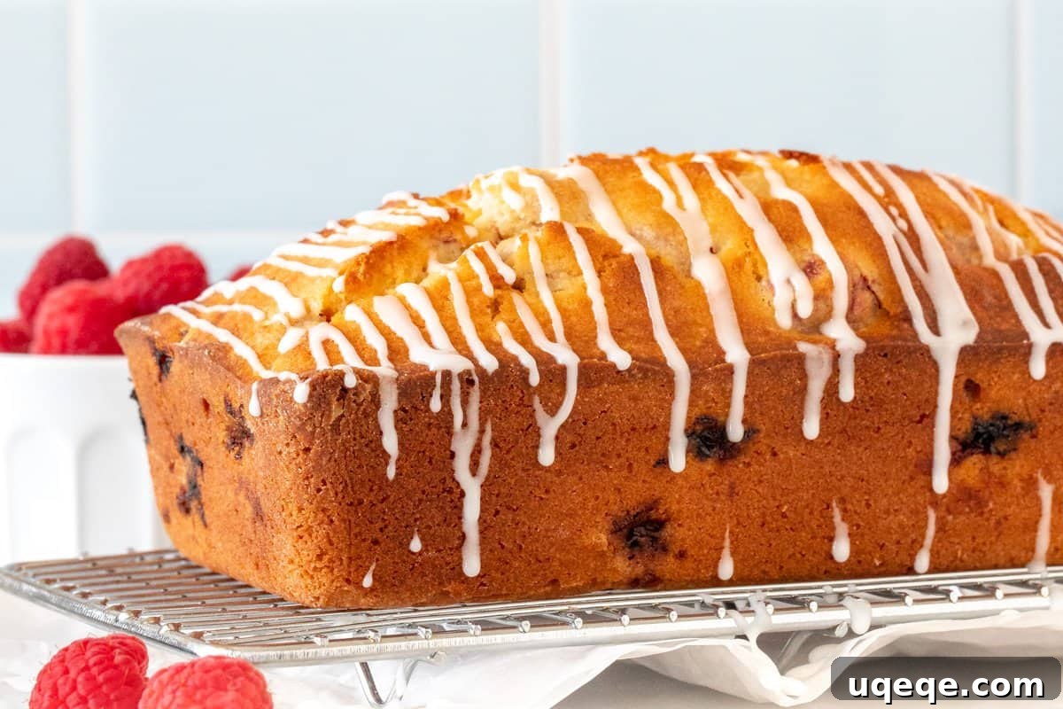 Tender Raspberry Bread Bursting with Juicy Berries 3 Raspberry bread loaf with a delicate drizzle of glaze on top, ready to be served