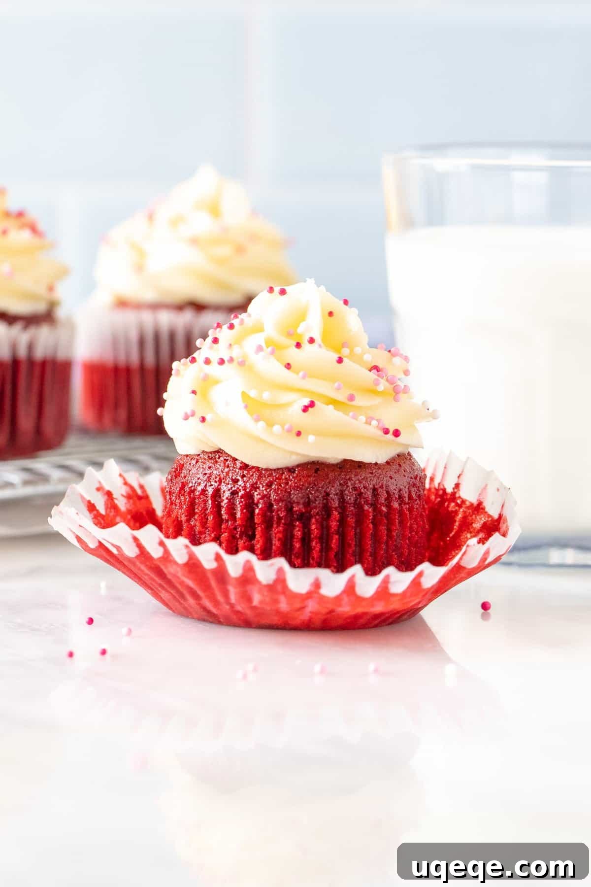 Just Enough Red Velvet Bliss 2 Red velvet cupcake with a glass of milk, showcasing the vibrant red color and cream cheese frosting.