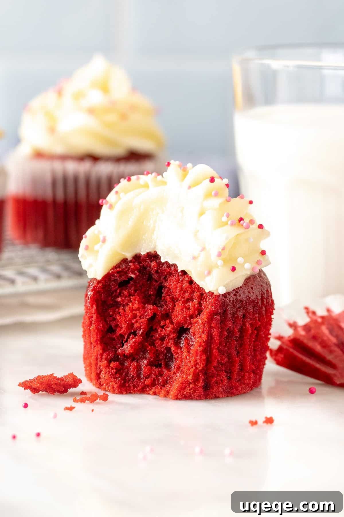 Just Enough Red Velvet Bliss 6 A single red velvet cupcake with a bite taken out, showing the moist red cake and thick cream cheese frosting.