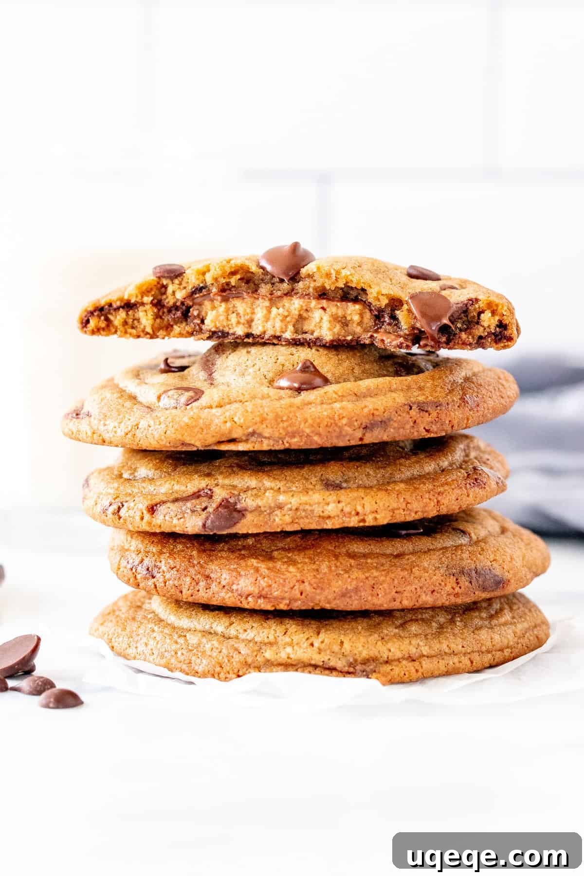Decadent Reese's Chocolate Chip Cookies 2 Stack of Reese's chocolate chip cookies with the top cookie broken in half, showing the peanut butter cup inside.