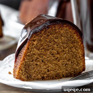 A delightful slice of bundt cake, perfectly moist and adorned with a generous swirl of chocolate ganache