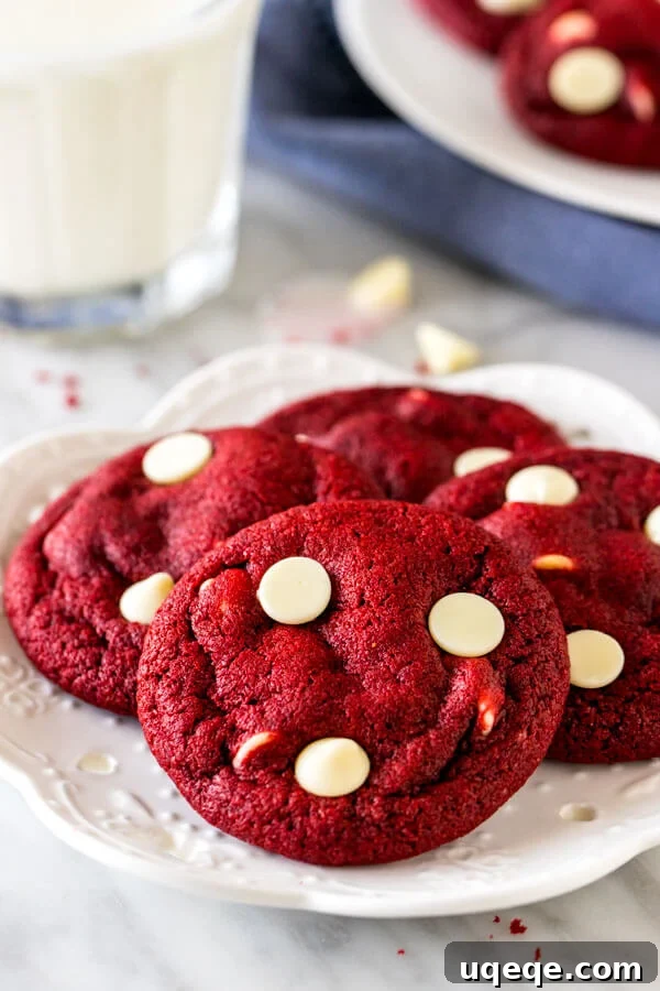 Ruby Red Chocolate Chip Indulgence 2 A plate of red velvet white chocolate chip cookies with a glass of milk