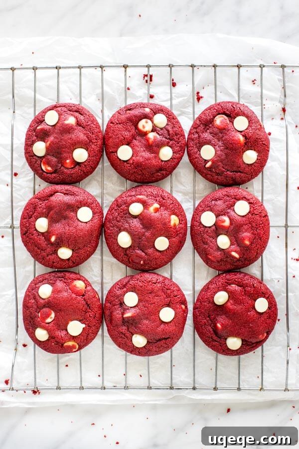 Ruby Red Chocolate Chip Indulgence 3 Red velvet chocolate chip cookies on a cooling rack, from overhead.