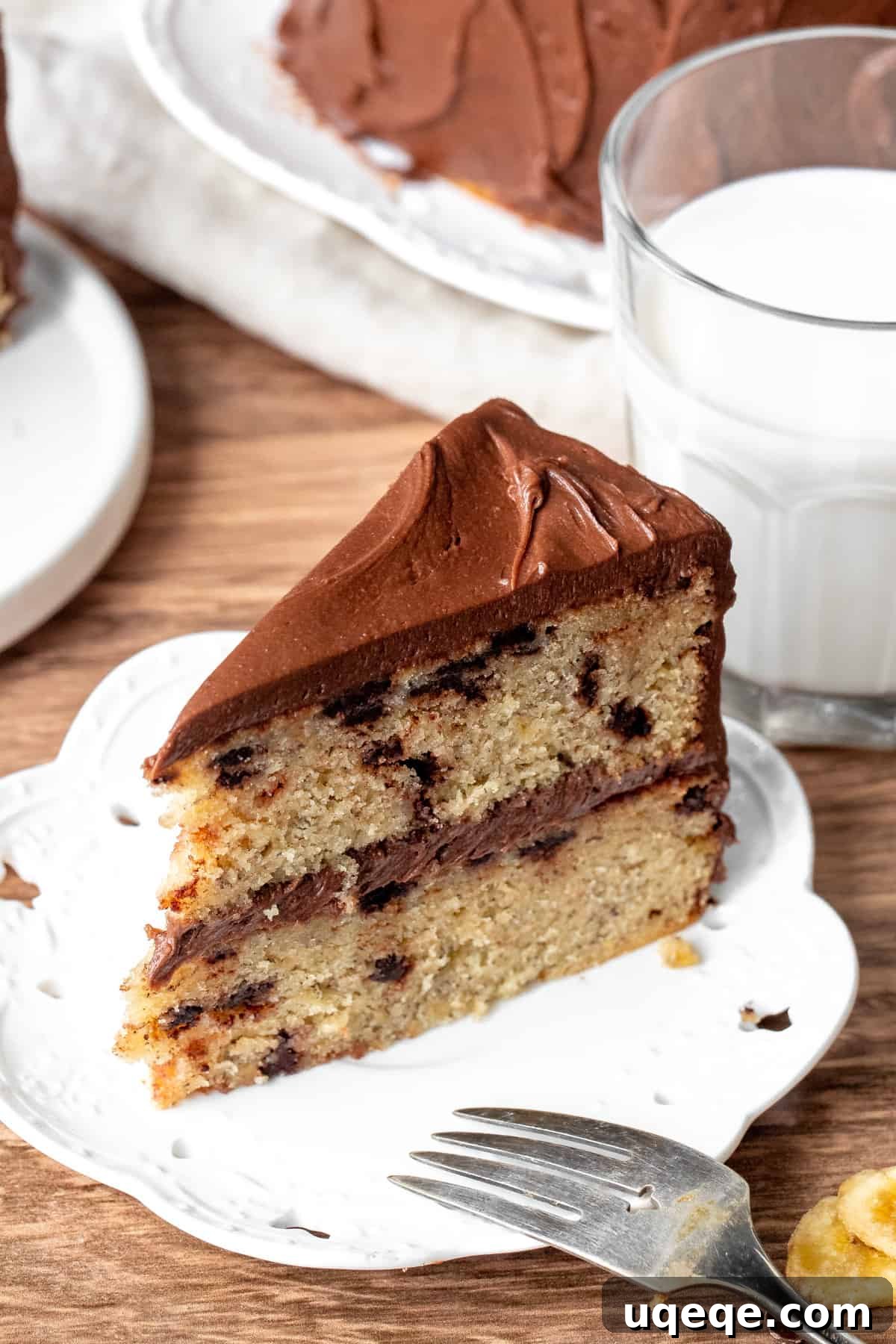 Decadent Banana Chocolate Chip Cake 5 Slice of moist banana chocolate chip cake with rich chocolate frosting on a white plate