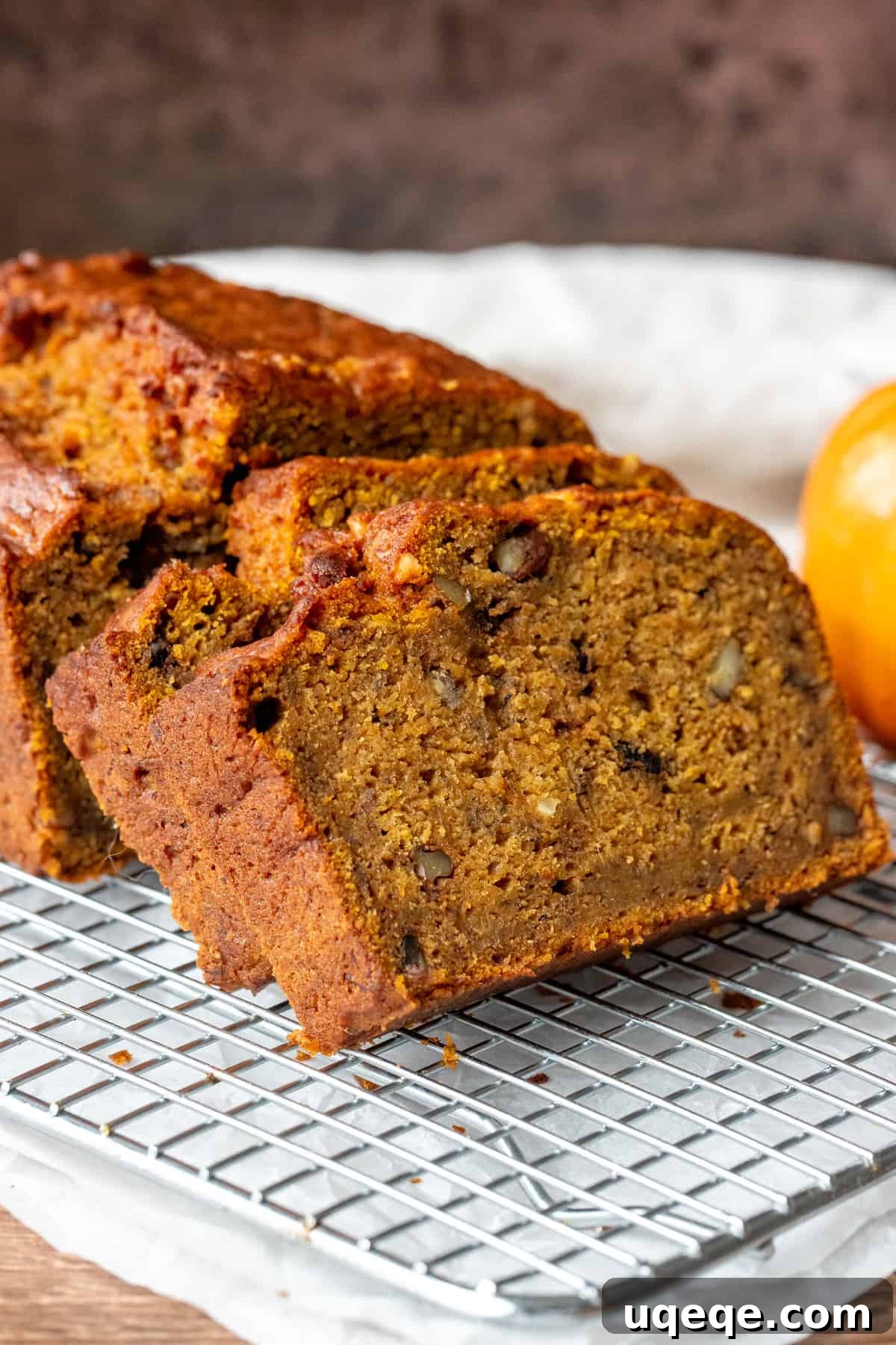 Banana pumpkin bread with a few slices cut on cooling rack, showcasing its moist texture.