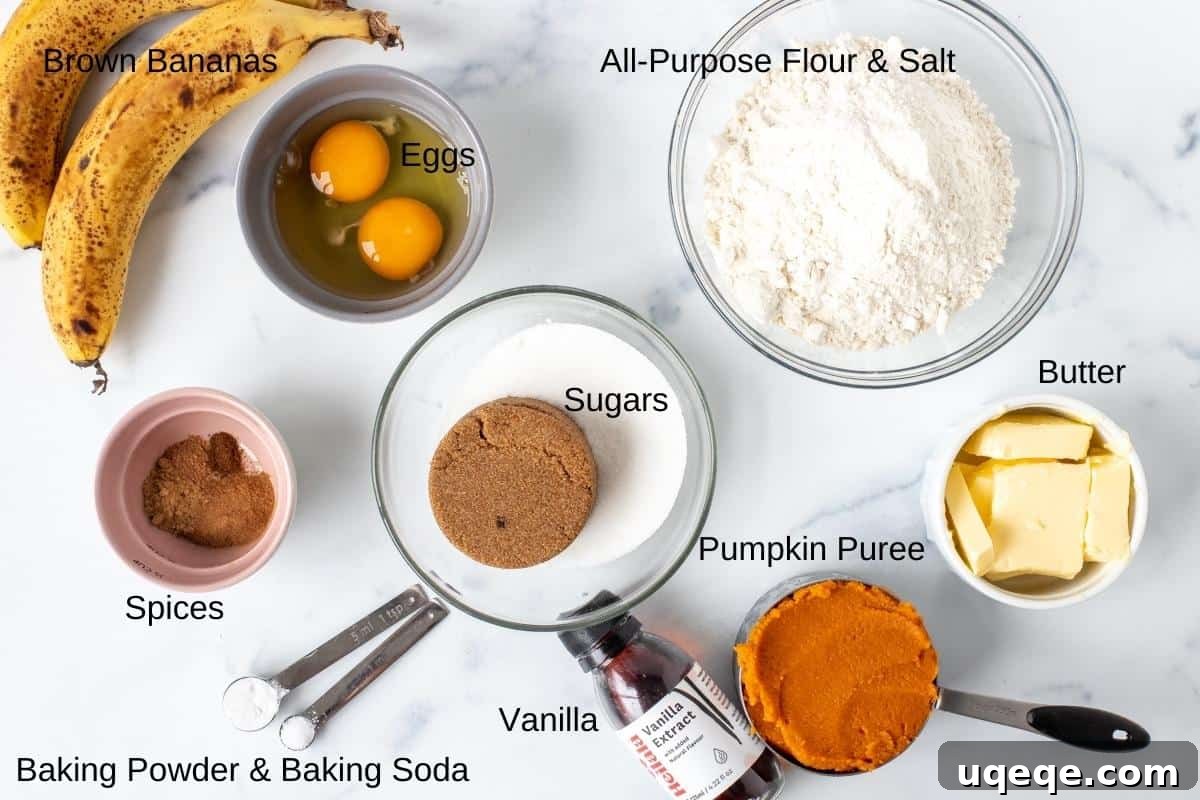 Pumpkin banana bread ingredients laid out on a table, including flour, spices, pumpkin puree, and bananas.