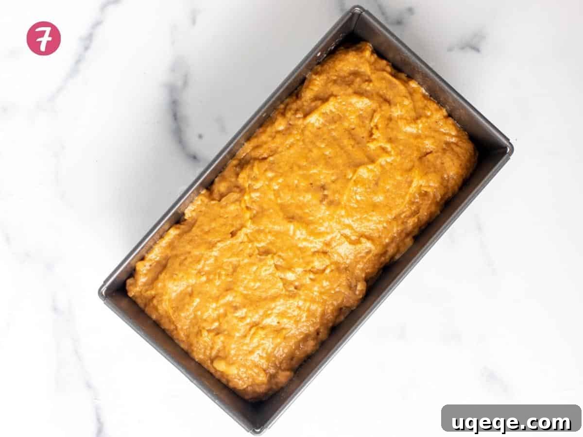Loaf pan filled with pumpkin banana bread batter, ready for baking.