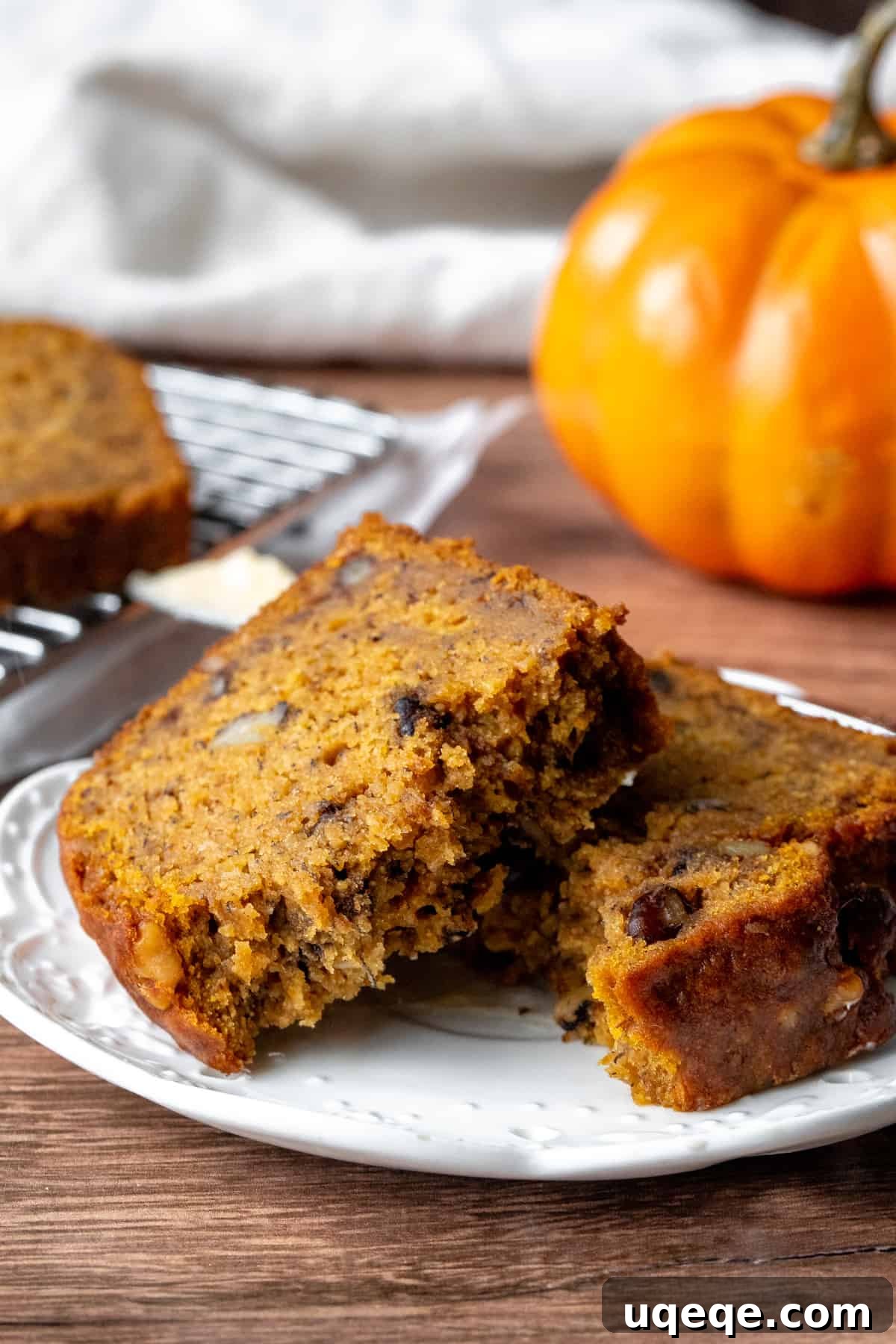 A slice of moist pumpkin spice banana bread, broken in half to show its tender interior.