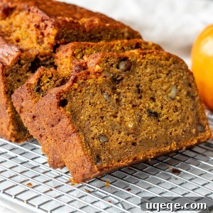 A whole pumpkin banana loaf with a few slices cut, ready to be served.
