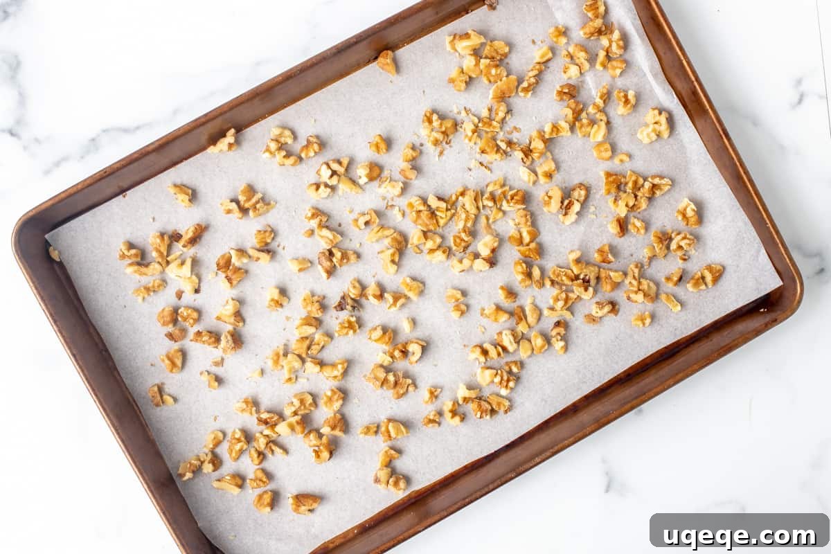 Decadent Chocolate Walnut Delights 3 Chopped walnuts spread evenly on a parchment-lined cookie sheet, ready for toasting
