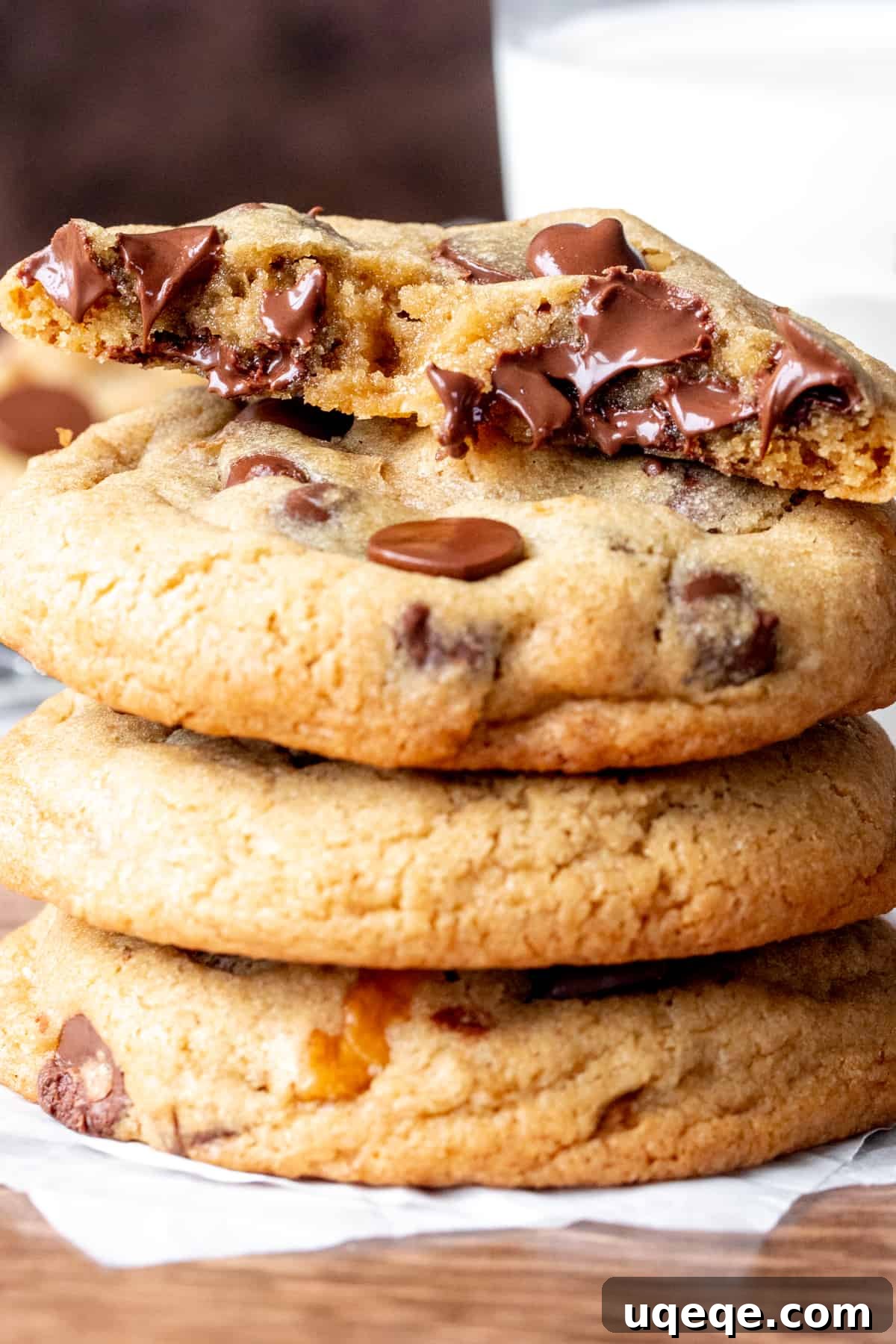 Decadent Chocolate Walnut Delights 5 Four walnut chocolate chip cookies stacked, with the top cookie broken in half to reveal its gooey interior and chocolate chips