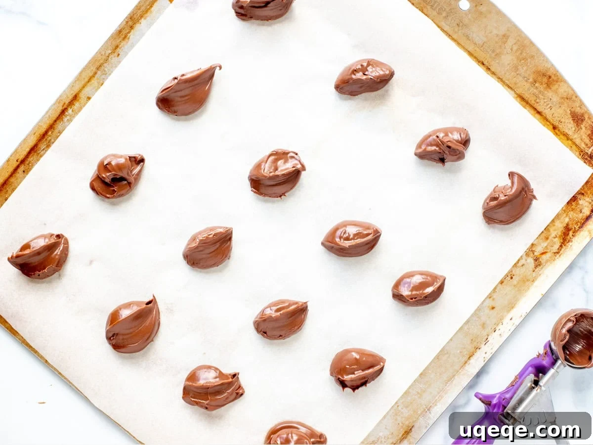 Nutella Lava Cookies 3 Neatly arranged spoonfuls of Nutella freezing on a lined cookie sheet, ready for stuffing.