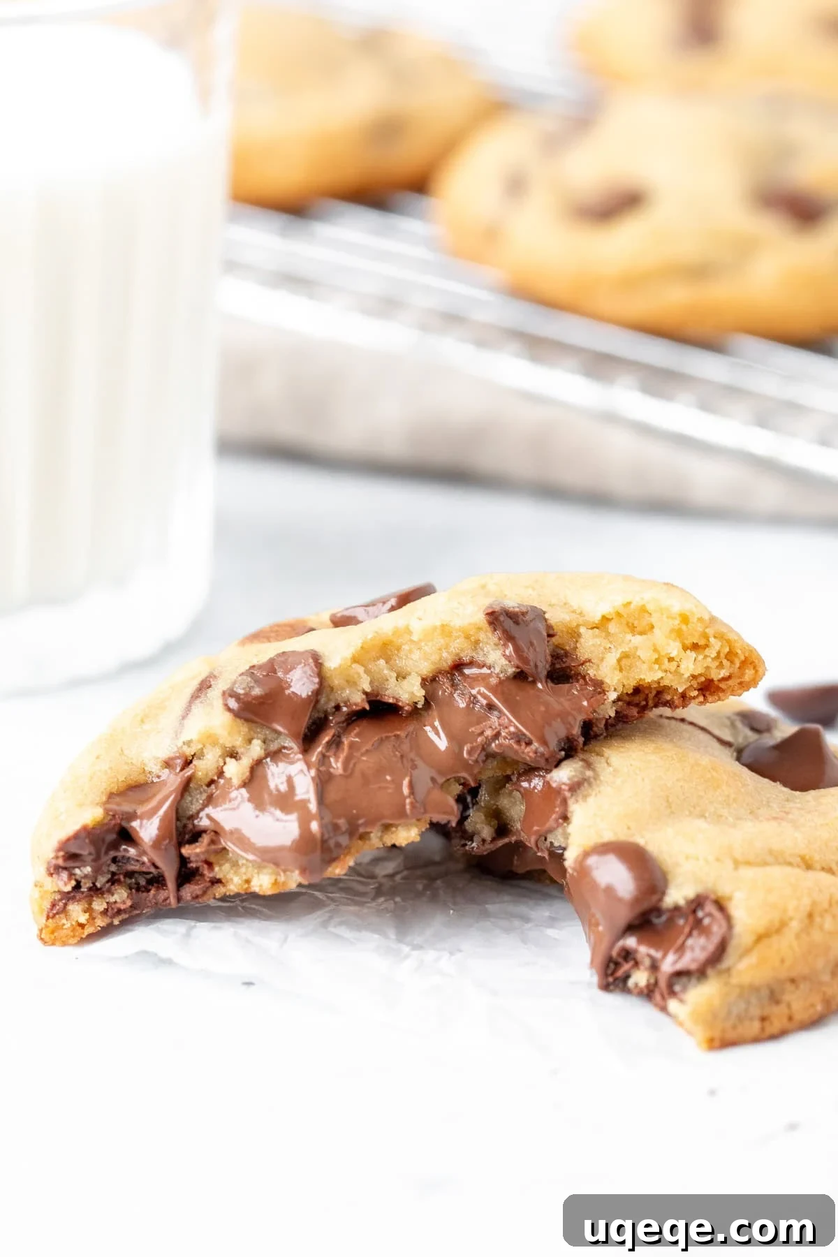 Nutella Lava Cookies 7 A Nutella stuffed cookie, perfectly broken in half to showcase the warm, gooey Nutella center, next to a refreshing glass of milk.