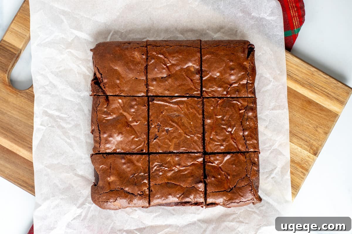 A freshly baked pan of gingerbread brownies on a cutting board, neatly sliced into nine perfect squares.