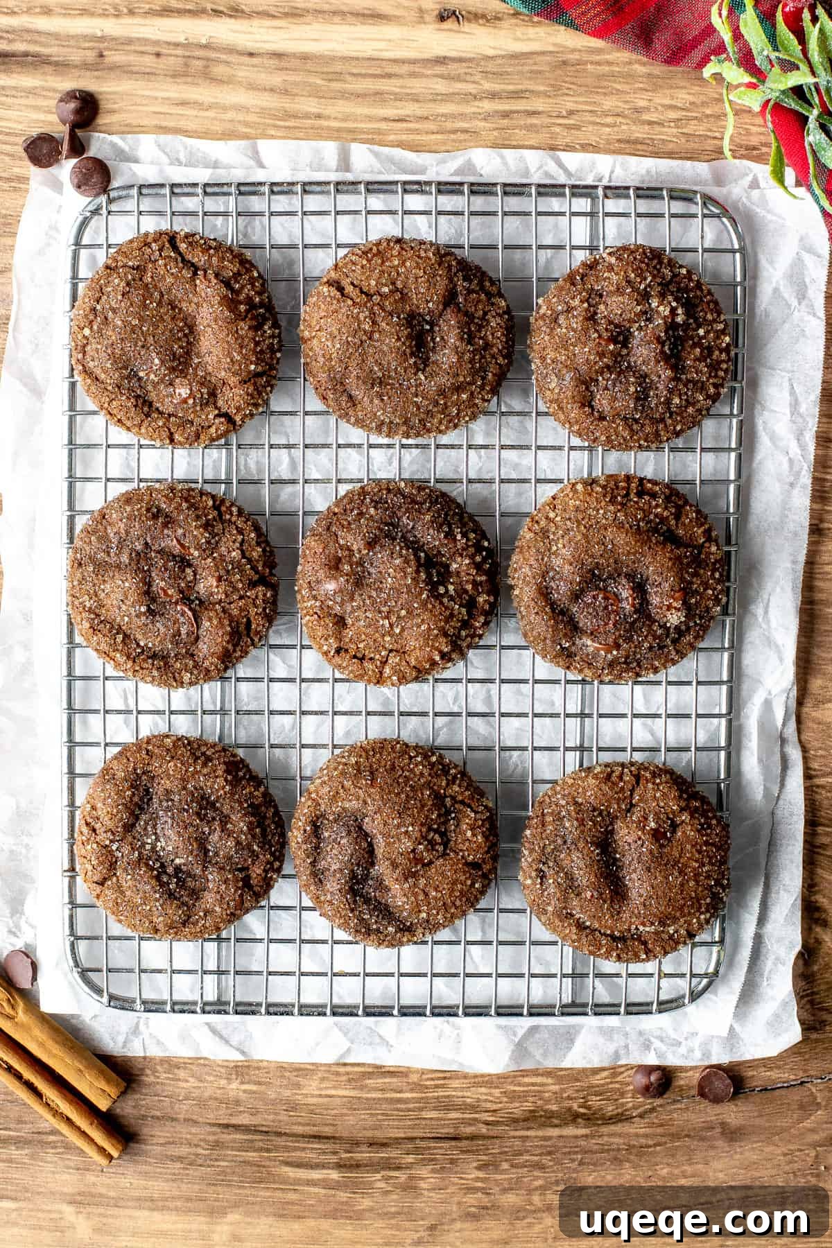 Freshly baked chocolate ginger molasses cookies, glistening with coarse sugar, cooling on a wire rack against a rustic background, ready to be enjoyed.