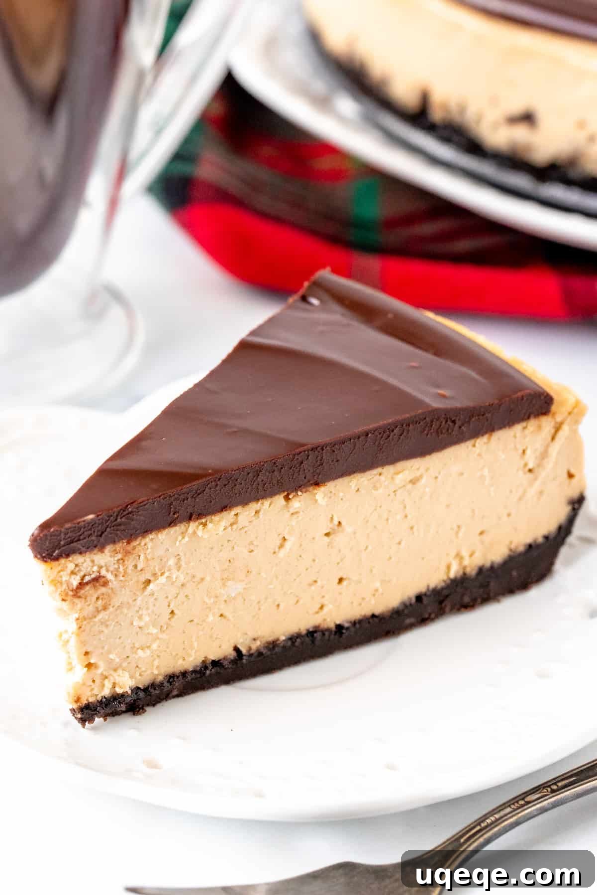 Oreo Crusted Kahlua Cheesecake 4 Slice of Kahlua cheesecake with chocolate ganache and a bite taken out