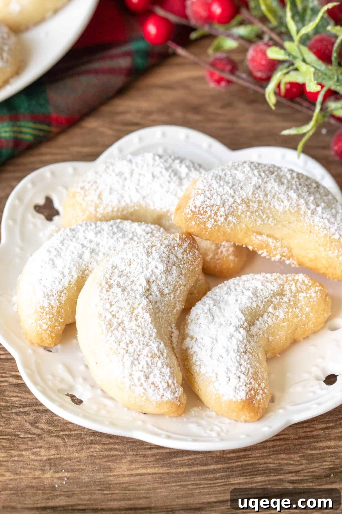 Small plate of buttery almond crescent cookies dusted with powdered sugar, perfect for holidays