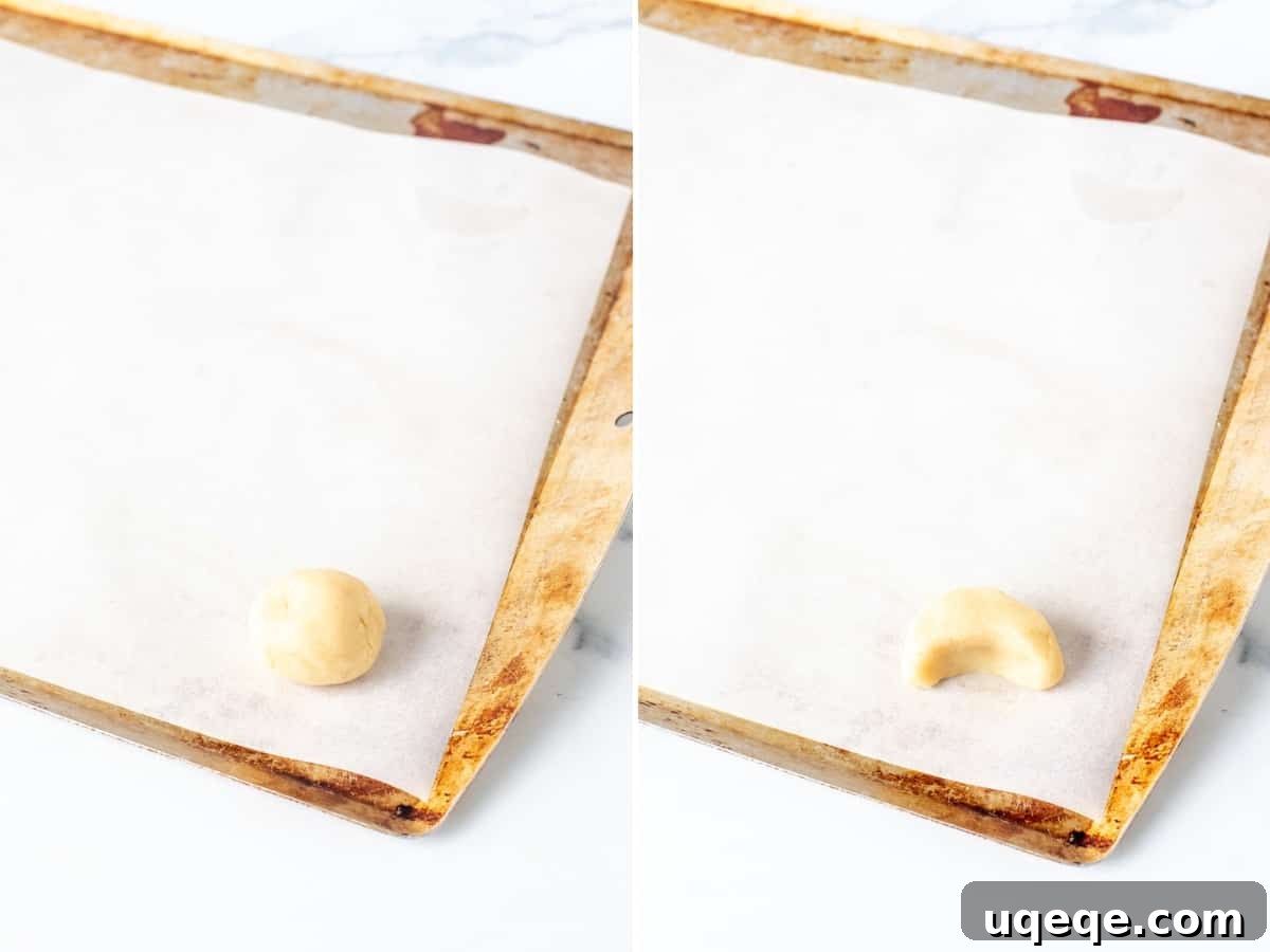 Cookie dough ball and perfectly shaped almond crescent cookie on a parchment-lined baking sheet