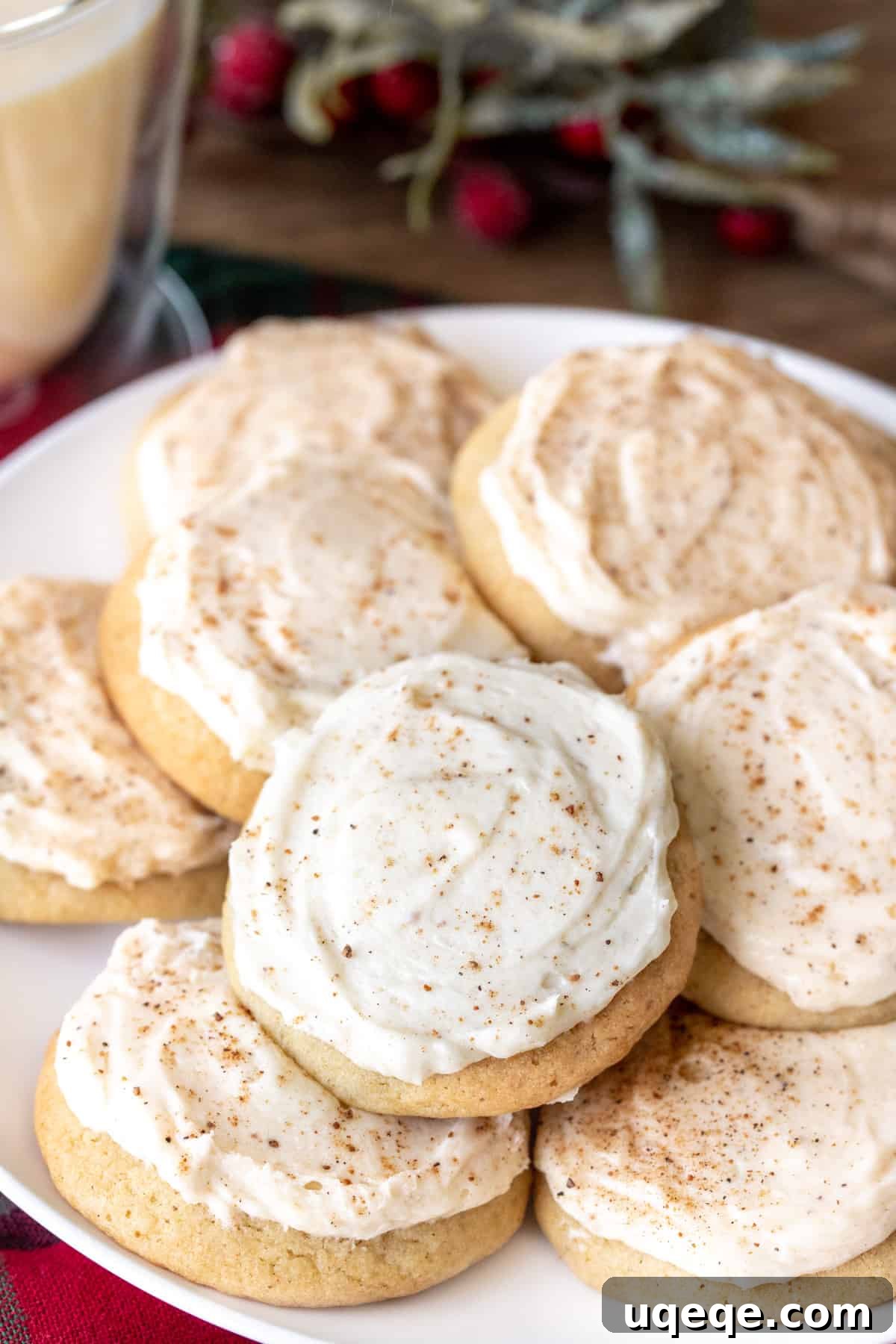 Spiced Eggnog Cookies with Creamy Frosting 4 A plate brimming with freshly baked eggnog cookies, each topped with a generous swirl of creamy eggnog buttercream and a dusting of nutmeg.