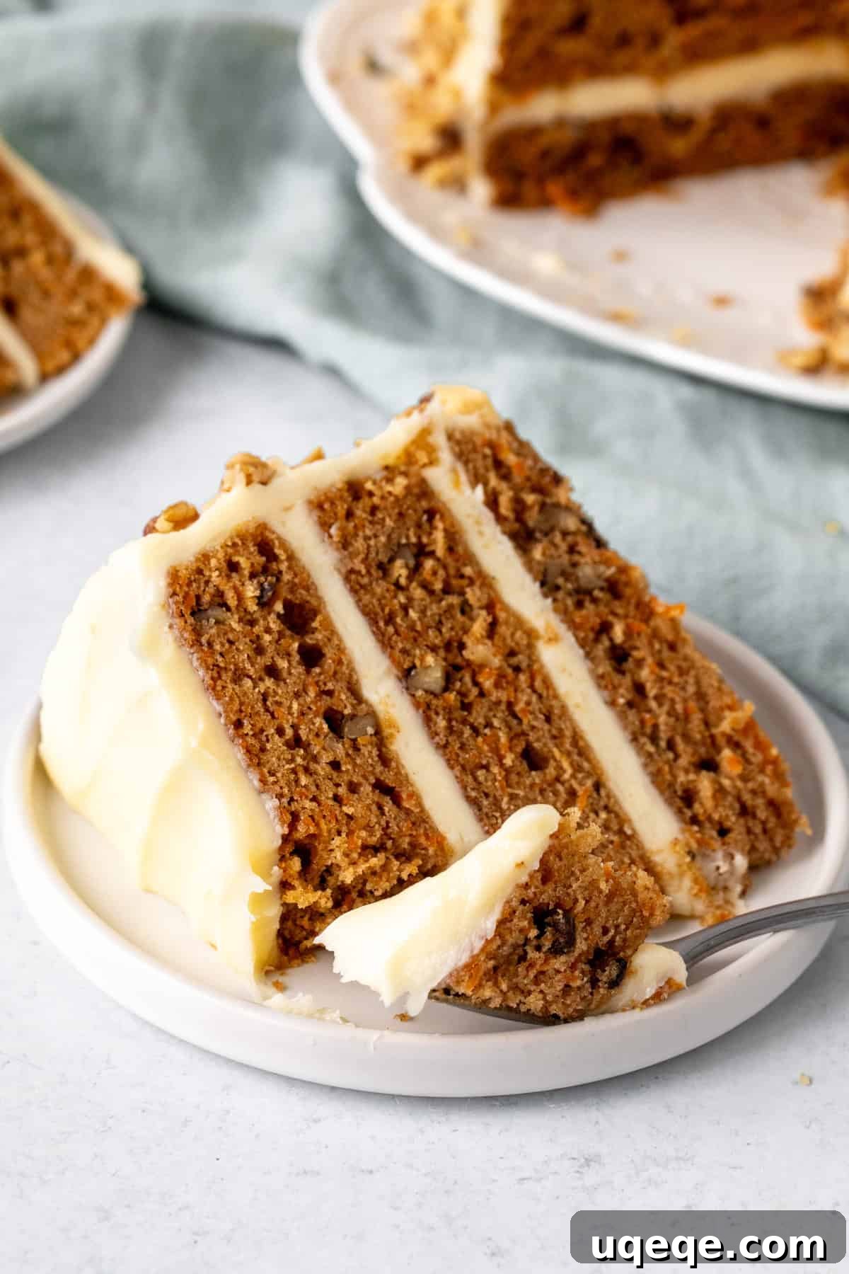 Classic Layered Carrot Cake with Cream Cheese Frosting 8 A perfectly sliced piece of moist carrot layer cake with thick cream cheese frosting and visible grated carrots.