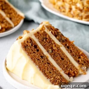 A delightful slice of carrot layer cake with generous cream cheese frosting, ready to be enjoyed.