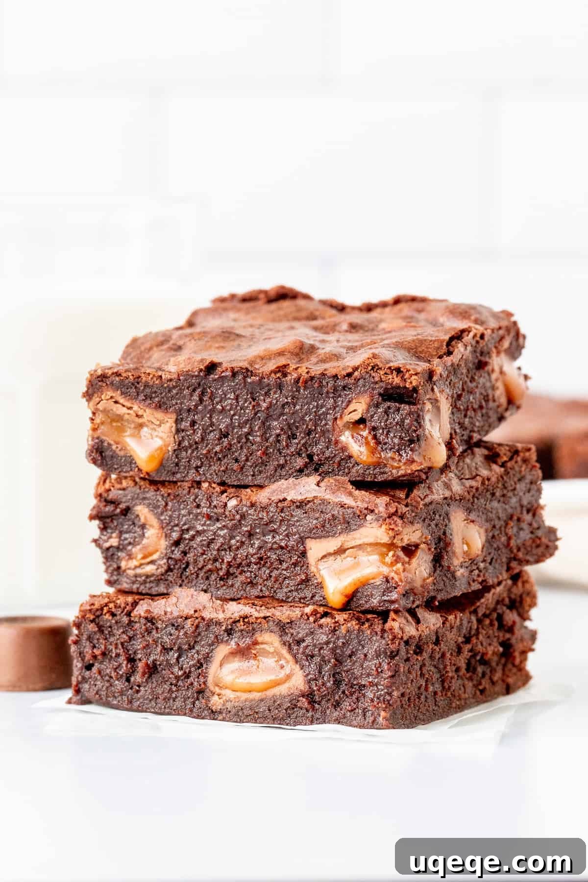 Gooey Rolo Stuffed Brownies 4 Three decadent brownies, each stuffed with visible pools of melted caramel, stacked invitingly