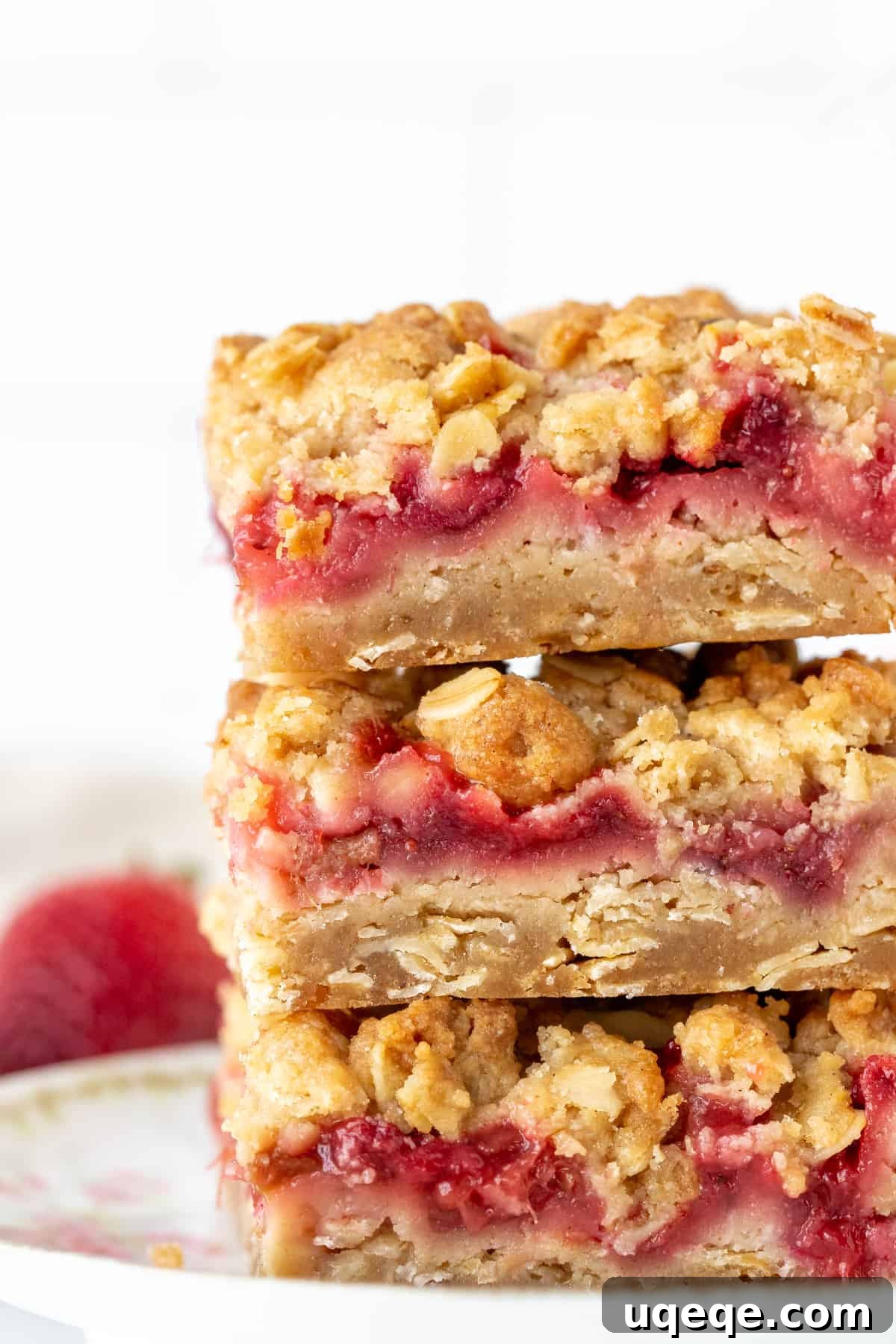 Sweet-Tart Strawberry Rhubarb Squares 2 Stack of three strawberry rhubarb bars, showcasing the delicious layers of oatmeal base, fruit filling, and crumble topping.