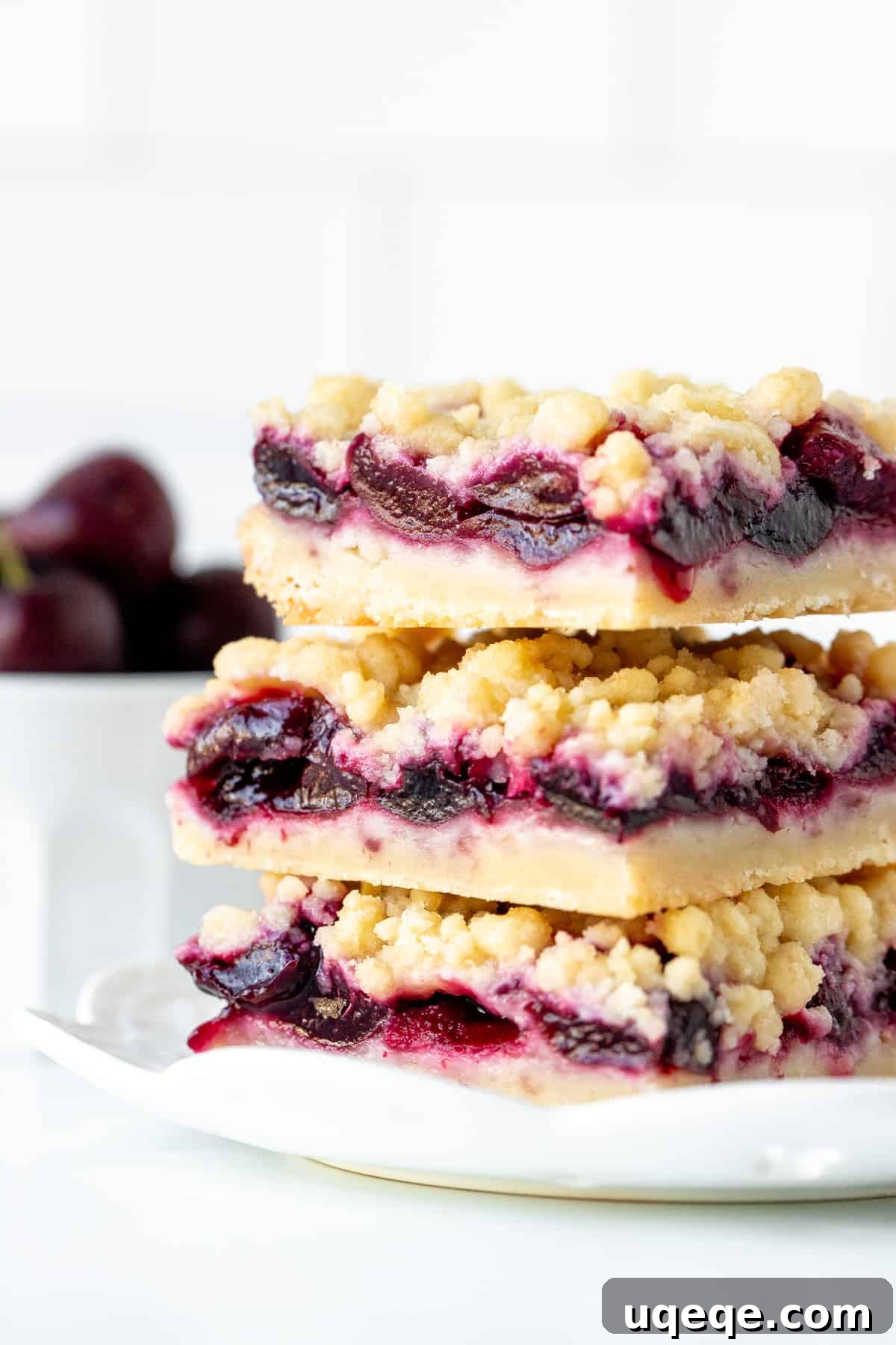Irresistible Cherry Crumble Bars 8 Three perfectly baked cherry shortbread bars with crumb topping, stacked on top of each other, showcasing the layers